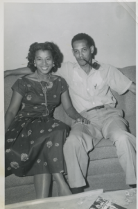 Black and white photo of a young Margarite and William Syphax sitting on a couch. smiling