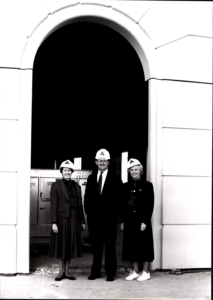 Ellen Bozman standing in an archway with an man and a woman, all wearing hard hats