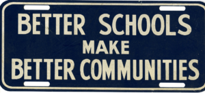 Blue license plate with white lettering, bearing the phrase the phrase, "Better Schools Make Better Communities," no date